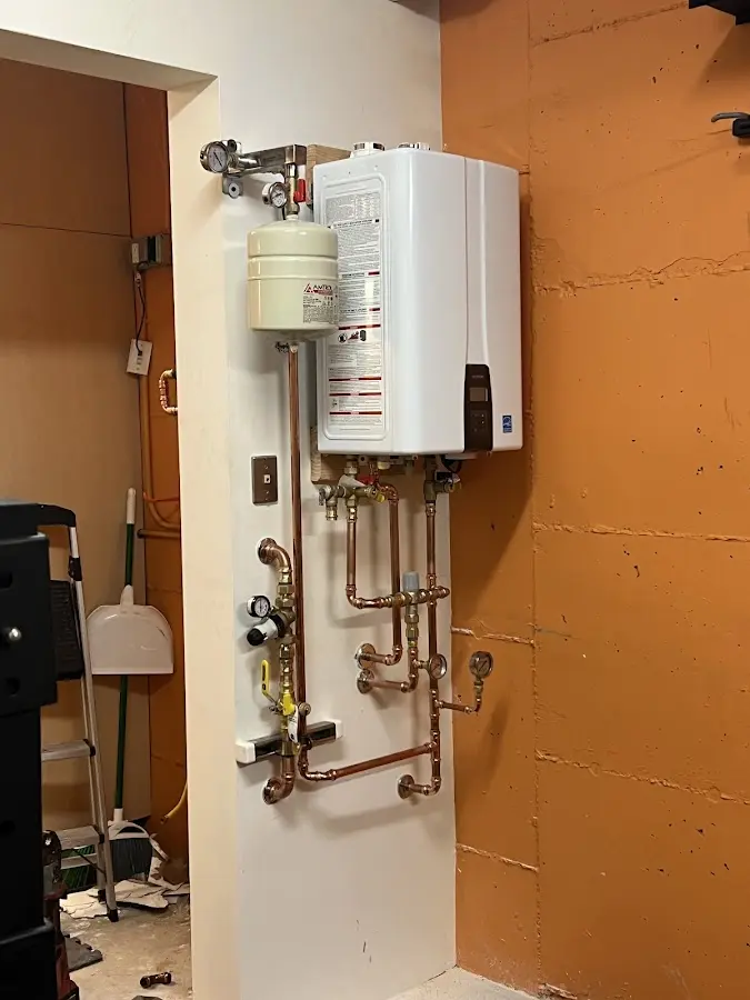 Plumbing technician inspecting water heater connections in Idylwood